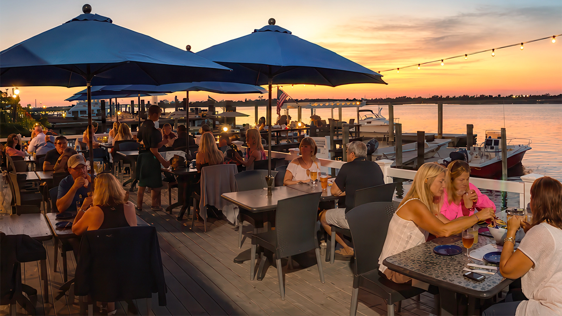 Outdoor waterfront dining at The Buoy Bar in Point Lookout, New York, at sunset